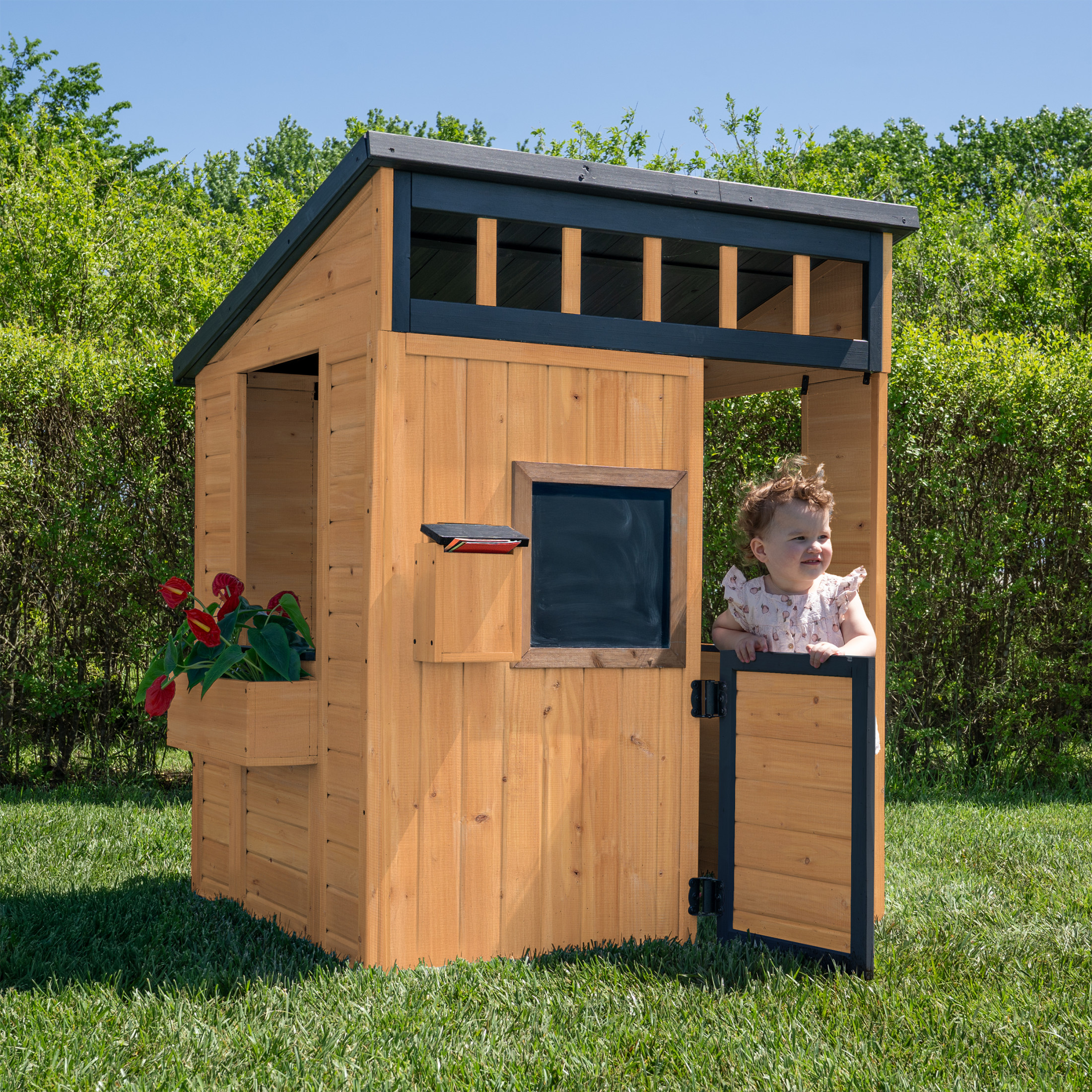 Backyard Discovery light brown Caraway Cottage playhouse with child playing